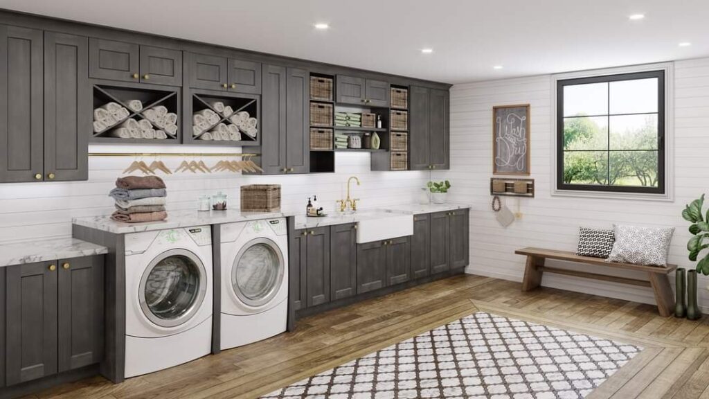 A large laundry room with a washer and dryer and gray cabinets.