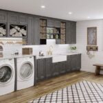 A large laundry room with a washer and dryer and gray cabinets.
