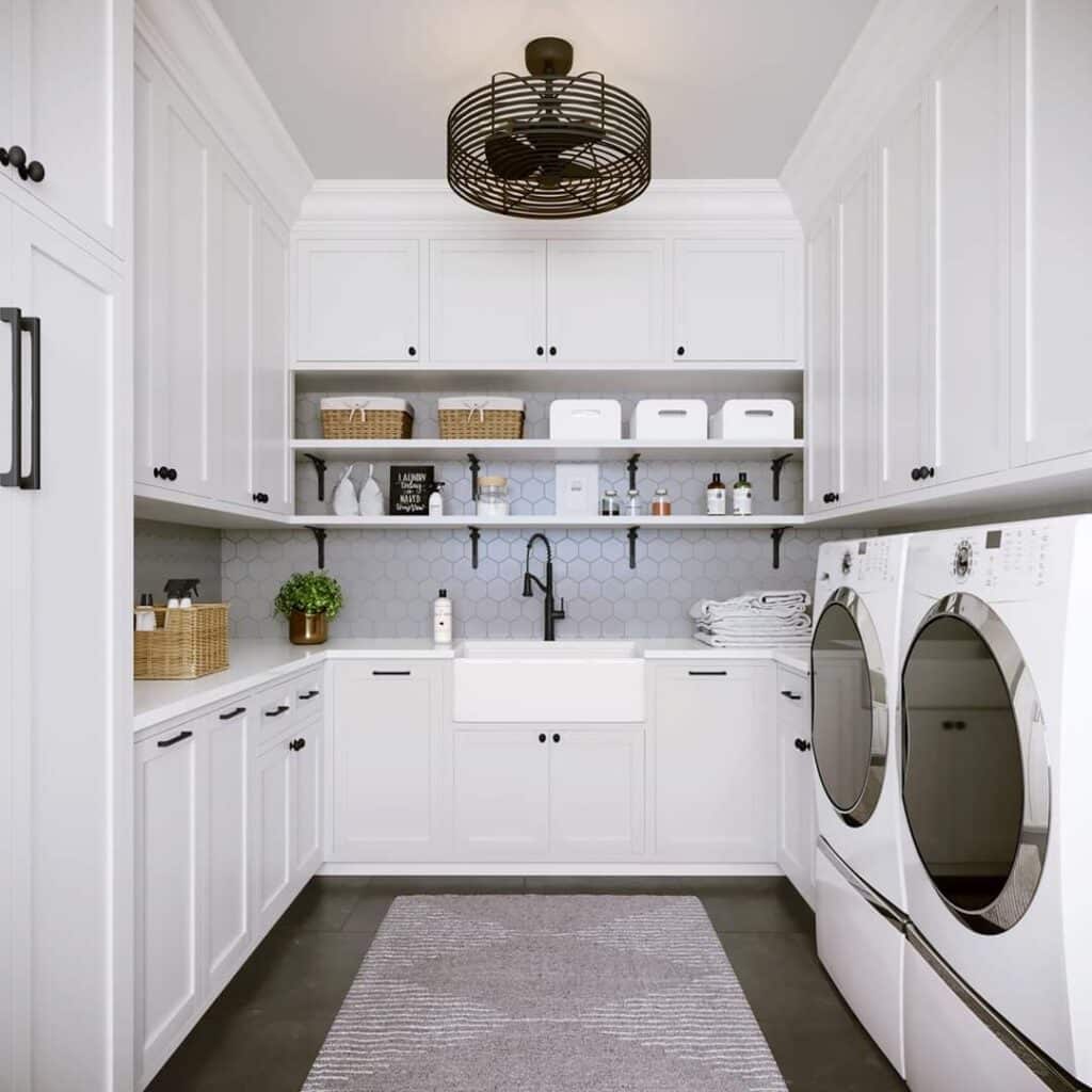 A large white laundry room with a washer and dryer, sink, and cabinets.